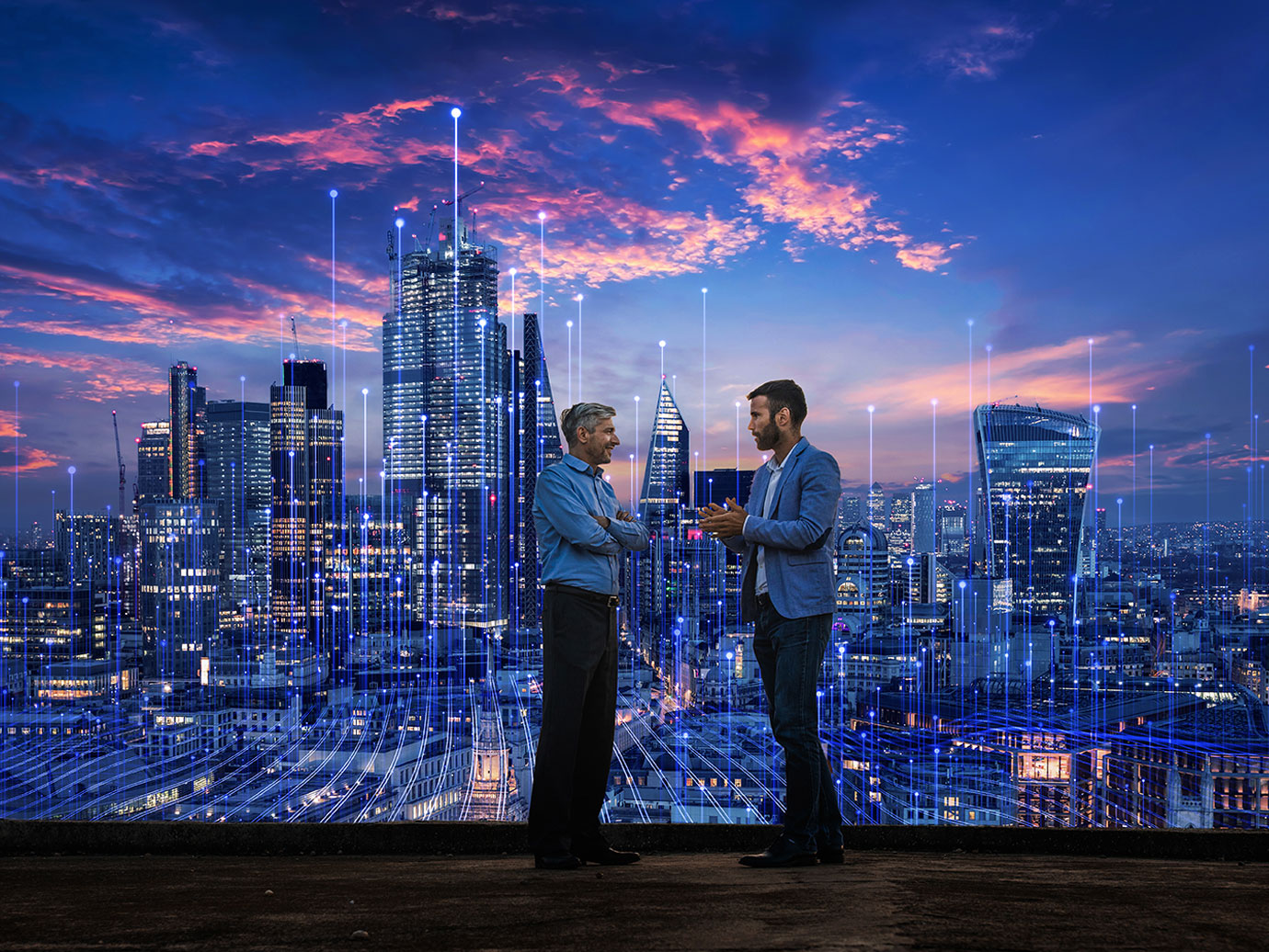 Two businessmen talking on the roof with a cityscape in the background with modern graphics